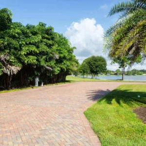 A brick road with trees and grass on both sides of it